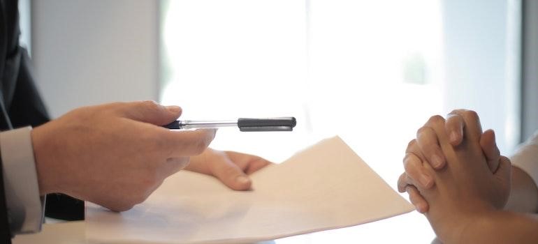 man offering a document to sign to a client